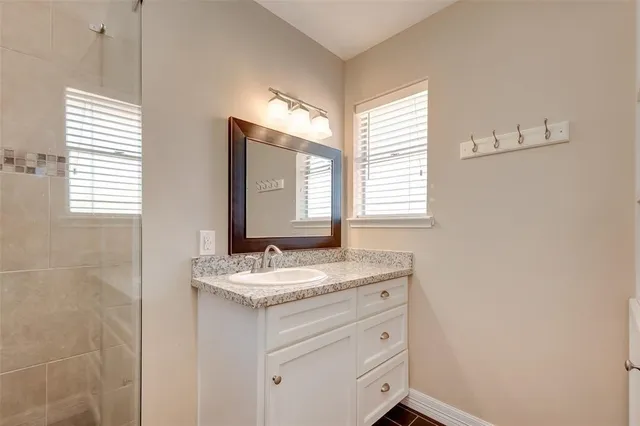 a bathroom with a sink vanity granite and a mirror