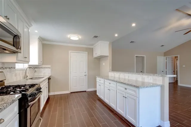 a kitchen with stainless steel appliances granite countertop a stove and a sink