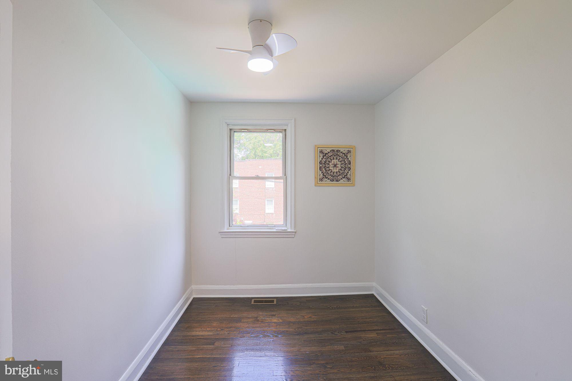 6203 Hopeton Avenue Baltimore, MD 21215 - Photo 15 of 18 an empty room with a window and hardwood floor