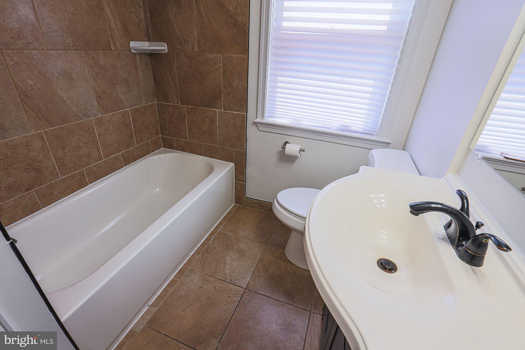 6203 Hopeton Avenue Baltimore, MD 21215 - Photo 18 of 18 a bathroom with a sink and a bathtub