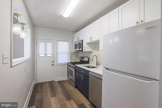 a kitchen with stainless steel appliances a sink stove and cabinets