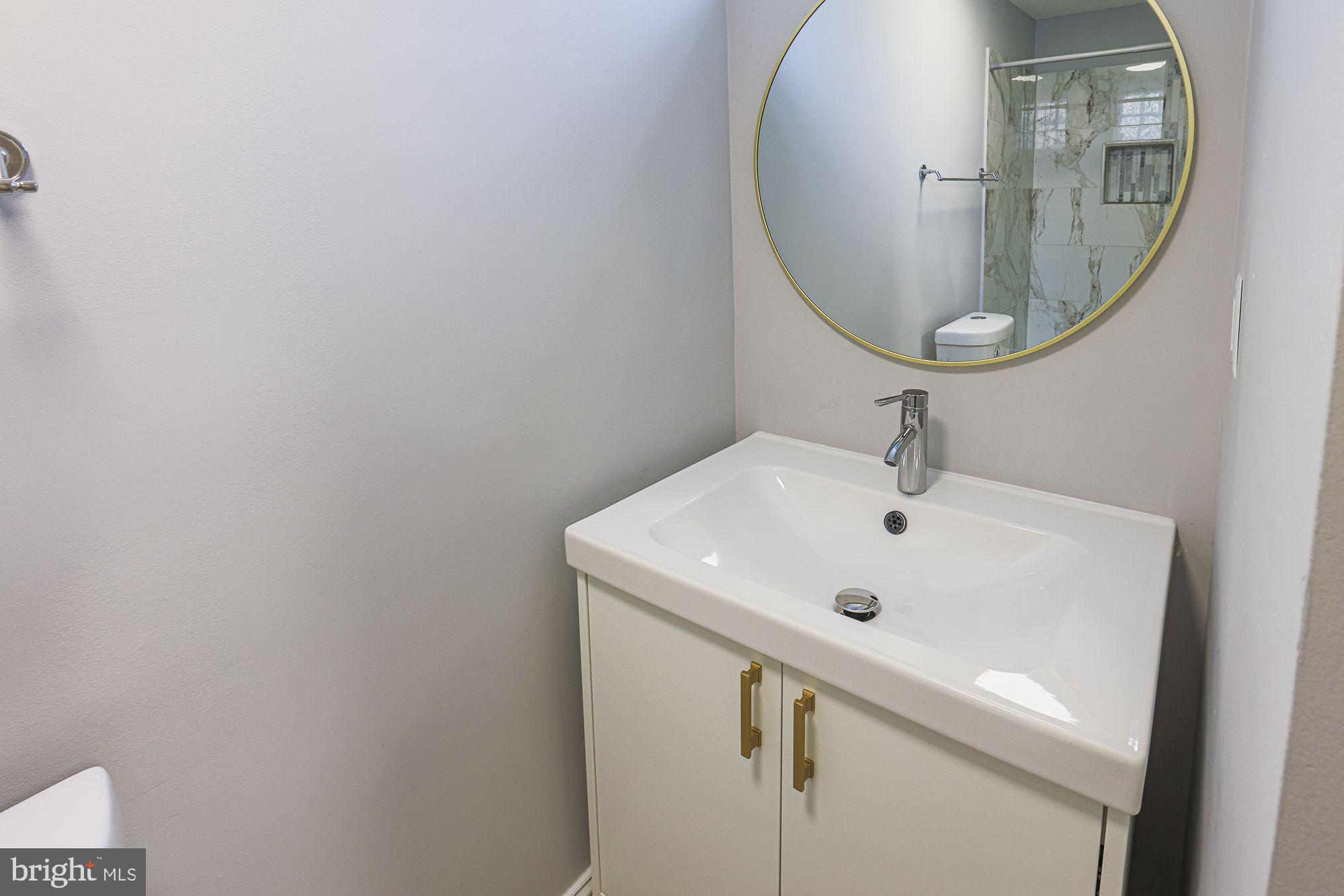 6203 Hopeton Avenue Baltimore, MD 21215 - Photo 10 of 18 a bathroom with a sink and a mirror