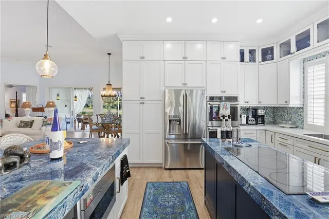 a kitchen with stainless steel appliances granite countertop a sink refrigerator and cabinets