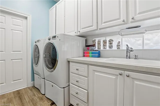a utility room with cabinets washer and dryer