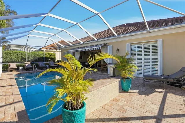 a view of a patio with table and chairs under an umbrella