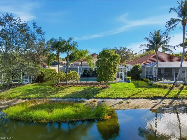 a view of a house with a yard and a lake view