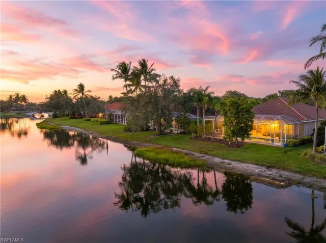 a view of a lake in front of a house with a yard and lake view