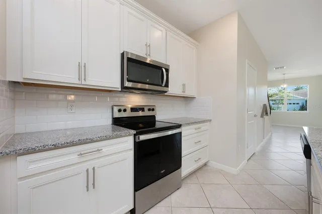 a kitchen with kitchen island granite countertop a sink and stove