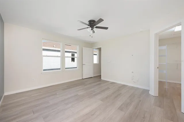 a view of a big room with wooden floor closet and windows