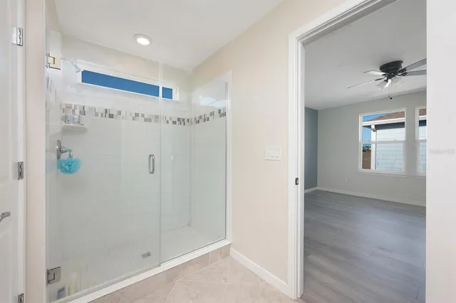 a bedroom with a bed a mirror and a flat tv screen on the dresser