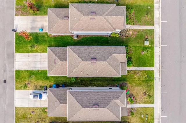 an aerial view of residential houses with yard