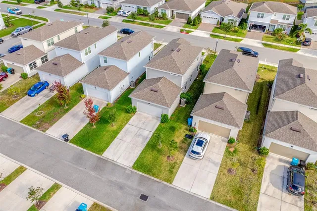 an aerial view of residential houses with yard