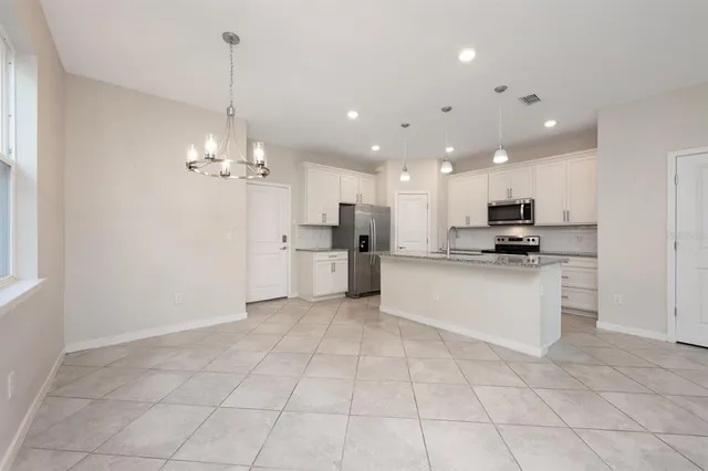 a view of kitchen with granite countertop cabinets a sink and a stove