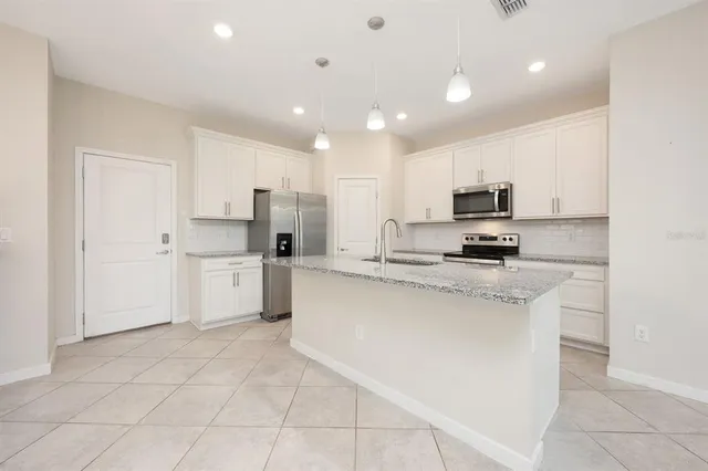 a kitchen with white cabinets a sink and white appliances