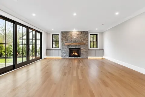 a view of empty room with wooden floor and fireplace