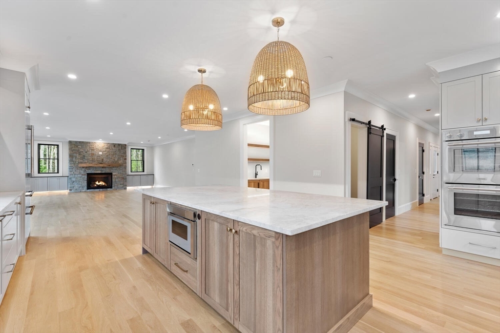 969 South Street Needham, MA 02492 - Photo 7 of 32 a kitchen with kitchen island granite countertop a sink a stove and a wooden floors