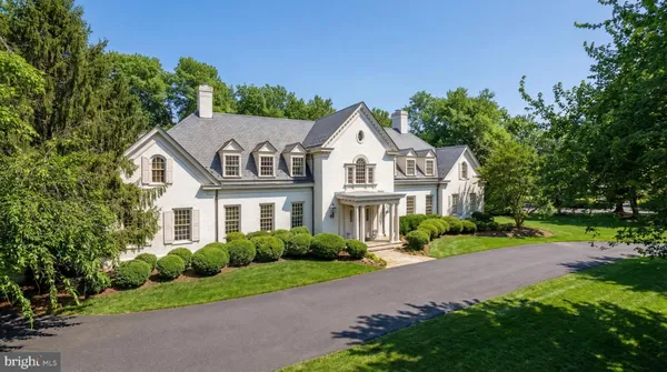 a view of a white house with a big yard and potted plants