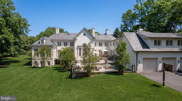 a front view of a house with a garden and trees