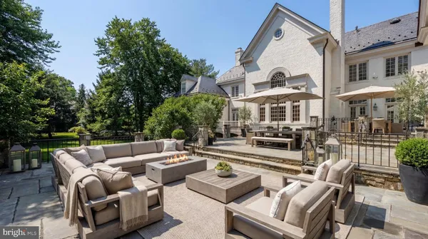 a view of a patio with couches and a table and chairs with wooden floor and fence