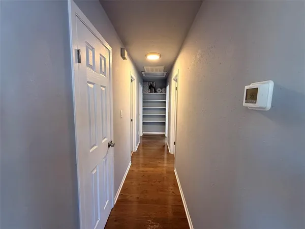 a view of a hallway with wooden floor and staircase