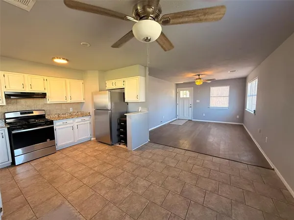 a kitchen with granite countertop a stove cabinets and stainless steel appliances