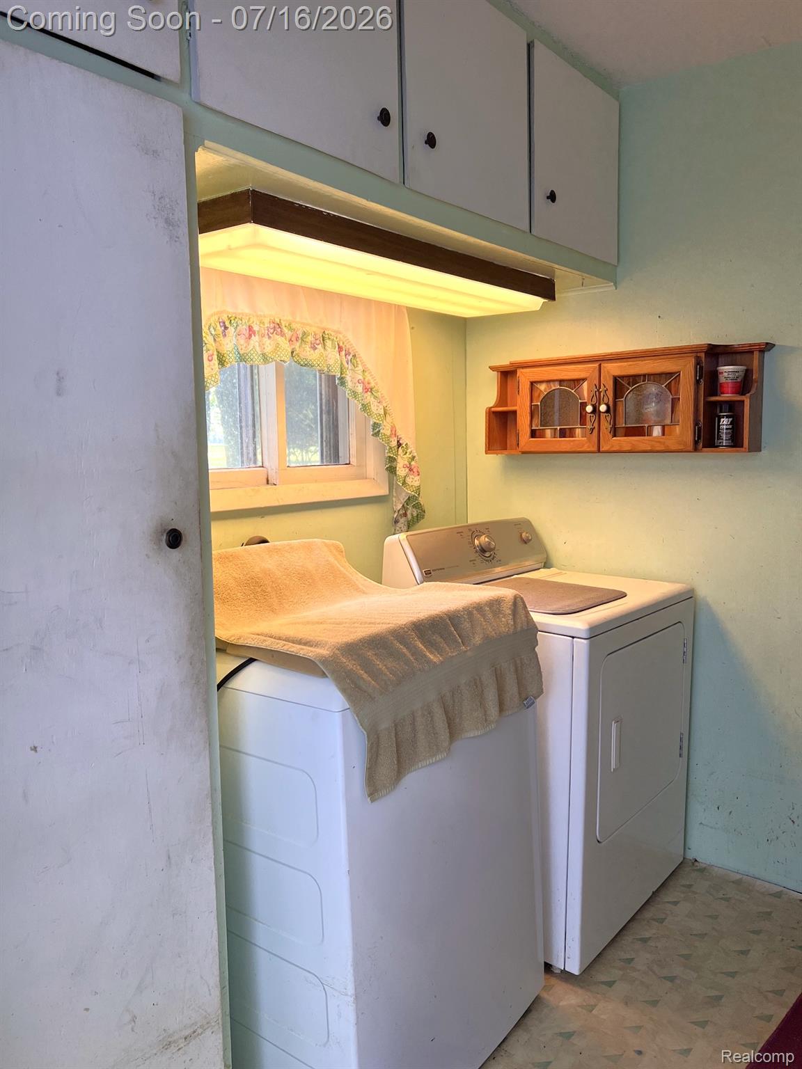 904 West Lovejoy Road Perry, MI 48872 - Photo 10 of 21 Laundry area featuring upper cabinetry, a single window, and a built-in overhead light fixture