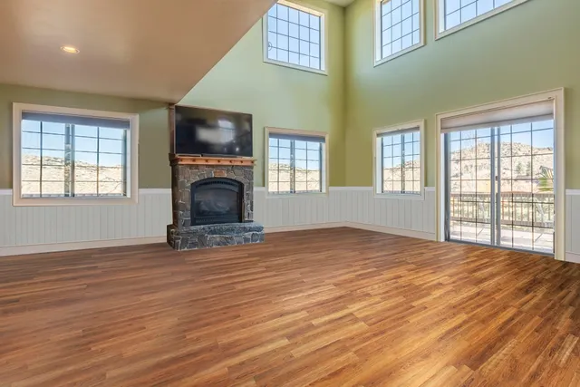 a view of empty room with wooden floor and fireplace