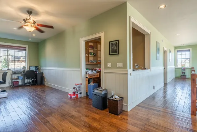 a view of a livingroom with wooden floor and a ceiling fan