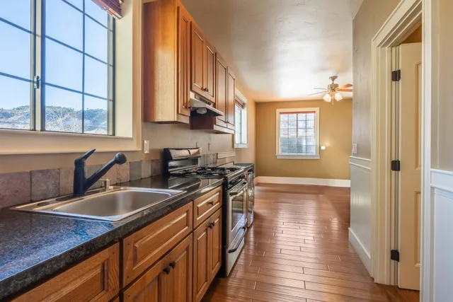 a kitchen with stainless steel appliances granite countertop a sink stove and cabinets