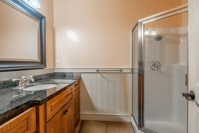a bathroom with a granite countertop sink and a mirror