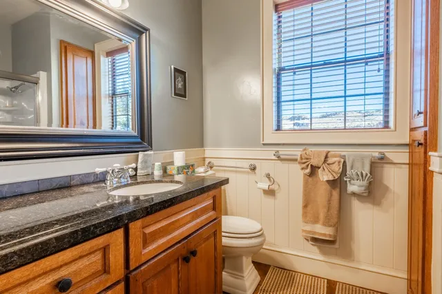 a bathroom with a granite countertop sink and a mirror