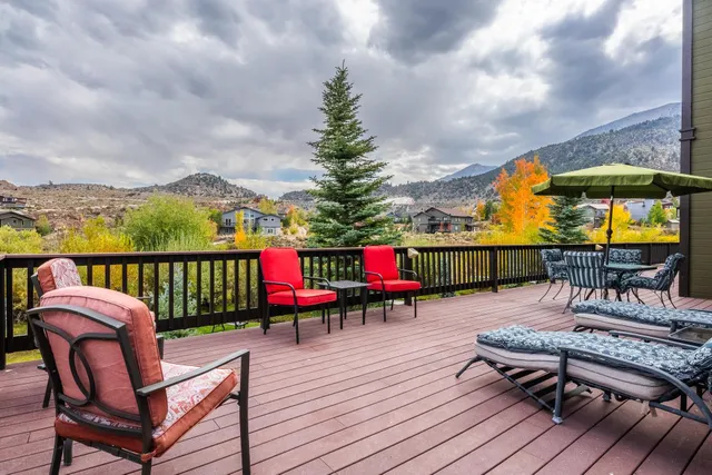 a balcony with wooden floor table and chairs