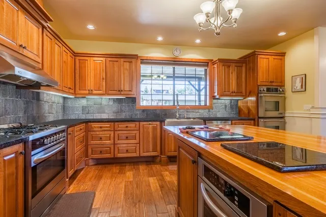 a kitchen with stainless steel appliances granite countertop a sink stove and cabinets