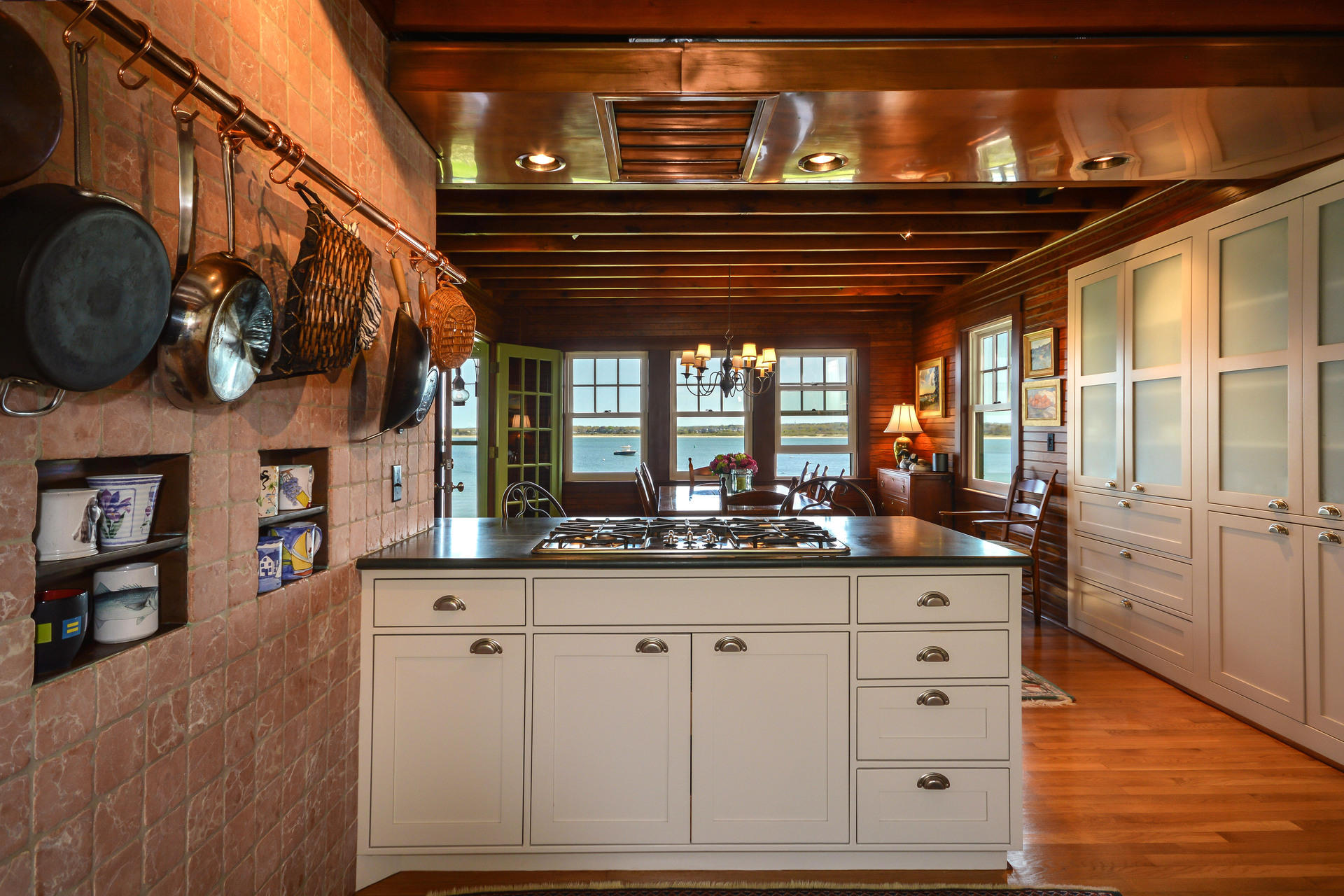 438 Scraggy Neck Road Cataumet, MA 02534 - Photo 12 of 33 a kitchen with white cabinets and chandelier