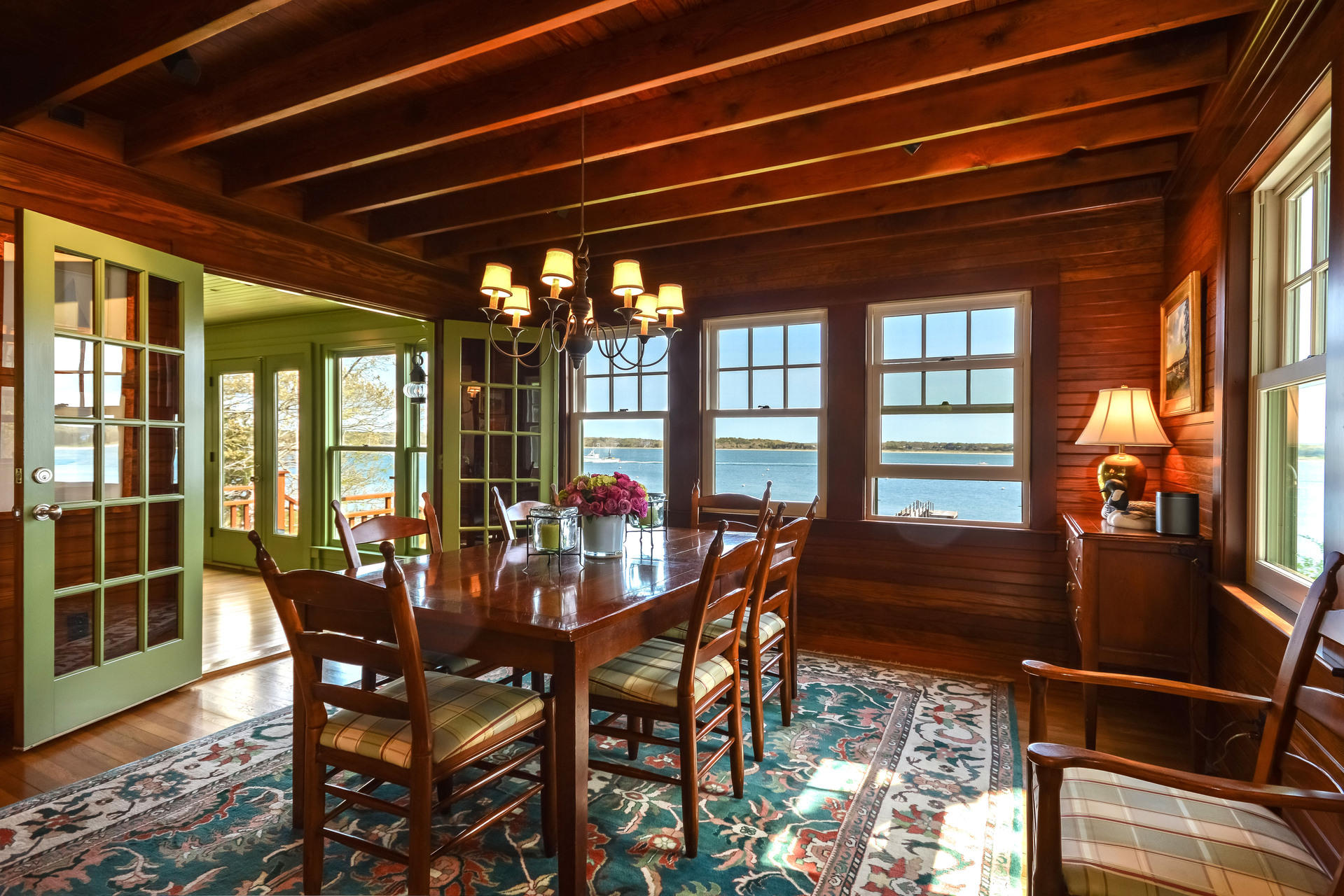 438 Scraggy Neck Road Cataumet, MA 02534 - Photo 9 of 33 a view of a dining room with furniture large windows and wooden floor