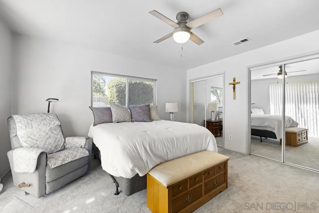 1007 Pepper Tree Lane Fallbrook, CA 92028 - Photo 17 of 34 a spacious bedroom with a bed a couch and a chandelier