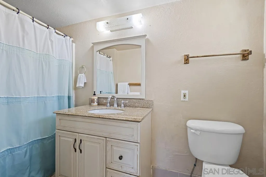 1007 Pepper Tree Lane Fallbrook, CA 92028 - Photo 18 of 34 a bathroom with a toilet sink and mirror