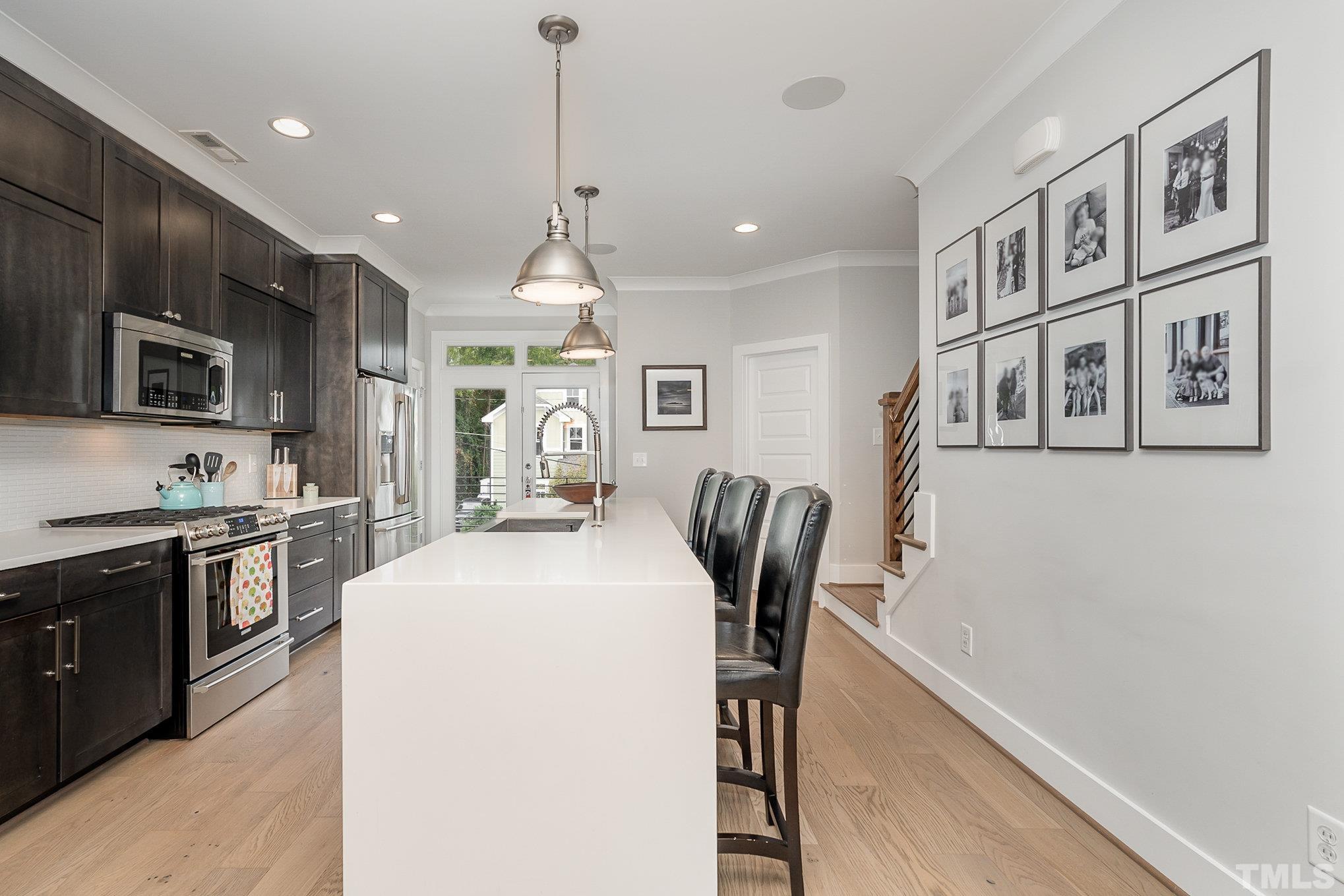 626 Watauga Street Raleigh, NC 27604 - Photo 5 of 30 a kitchen with stainless steel appliances granite countertop a refrigerator a stove top oven a sink a dining table and chairs