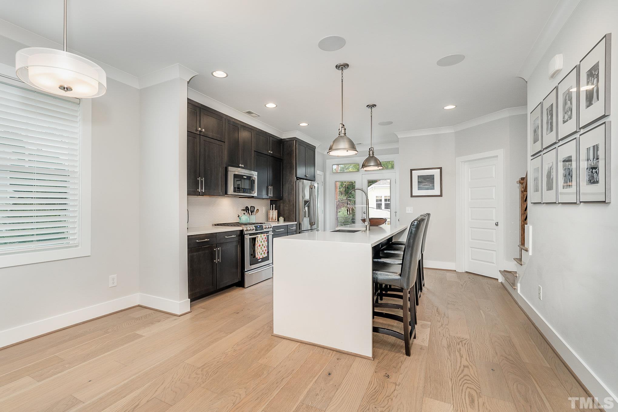 626 Watauga Street Raleigh, NC 27604 - Photo 7 of 30 a kitchen with a table chairs refrigerator and microwave