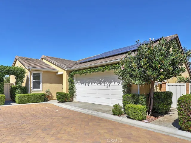 a front view of a house with a yard and potted plants