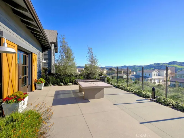 a view of a patio with couches and a table and chairs under an umbrella