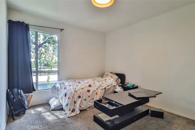 a bed sitting in a bedroom next to a window