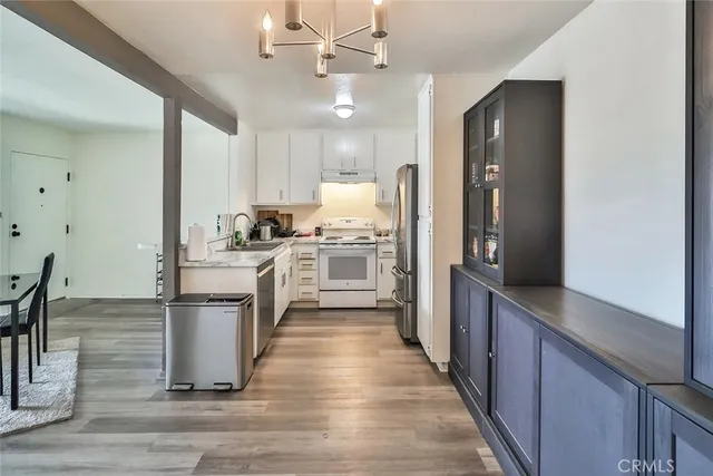 a kitchen with kitchen island a sink appliances and cabinets