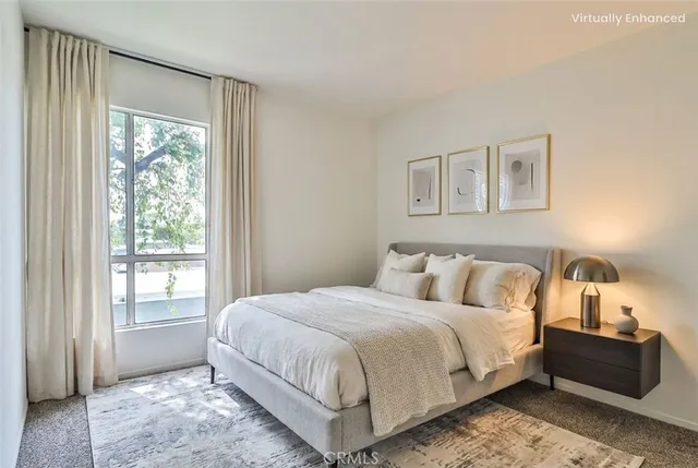 a large bed sitting in a bedroom next to a window