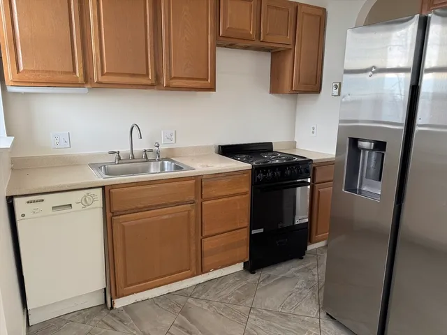 a kitchen with stainless steel appliances granite countertop a stove a refrigerator and a sink