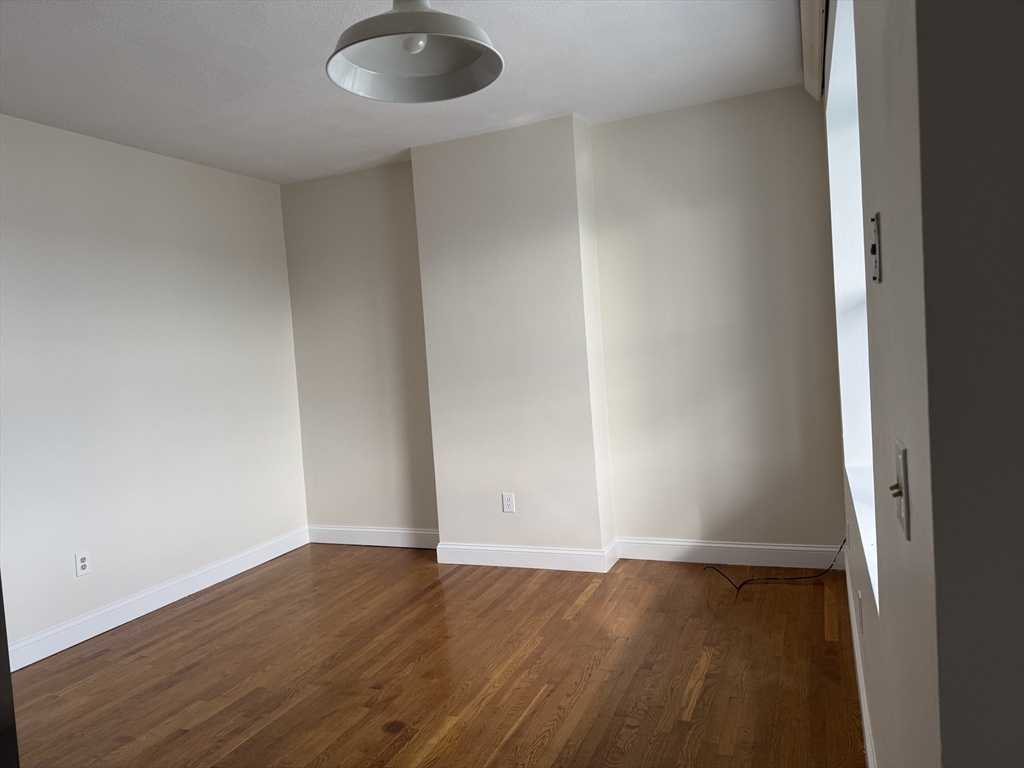 25-31 Maverick Square, Unit 5 Boston, MA 02128 - Photo 4 of 26 an empty room with wooden floor and windows