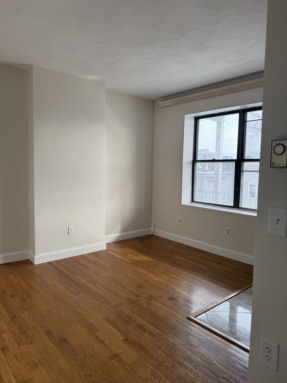 25-31 Maverick Square, Unit 5 Boston, MA 02128 - Photo 5 of 26 an empty room with wooden floor and windows