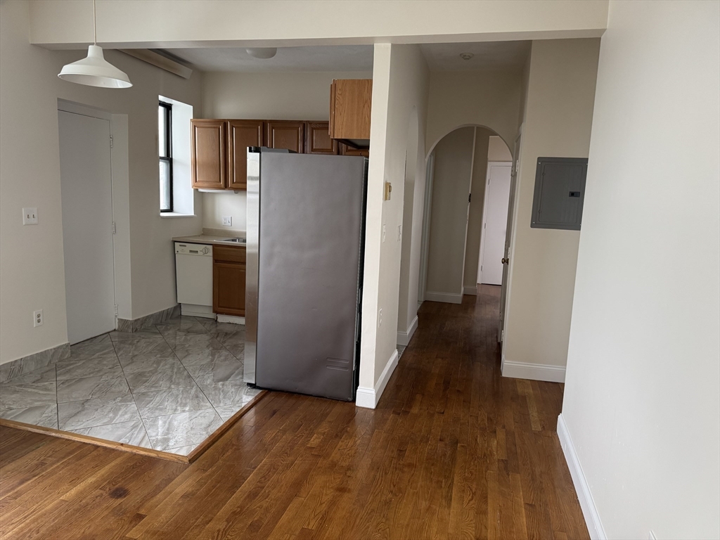 25-31 Maverick Square, Unit 5 Boston, MA 02128 - Photo 7 of 26 a view of a kitchen with wooden floor and a refrigerator