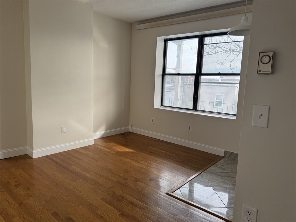 25-31 Maverick Square, Unit 5 Boston, MA 02128 - Photo 10 of 26 an empty room with wooden floor and windows