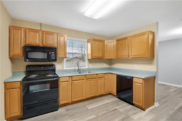 a kitchen with stainless steel appliances granite countertop a stove a sink and a microwave